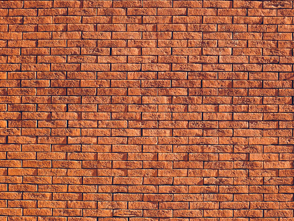 A wall of red clay bricks, close up