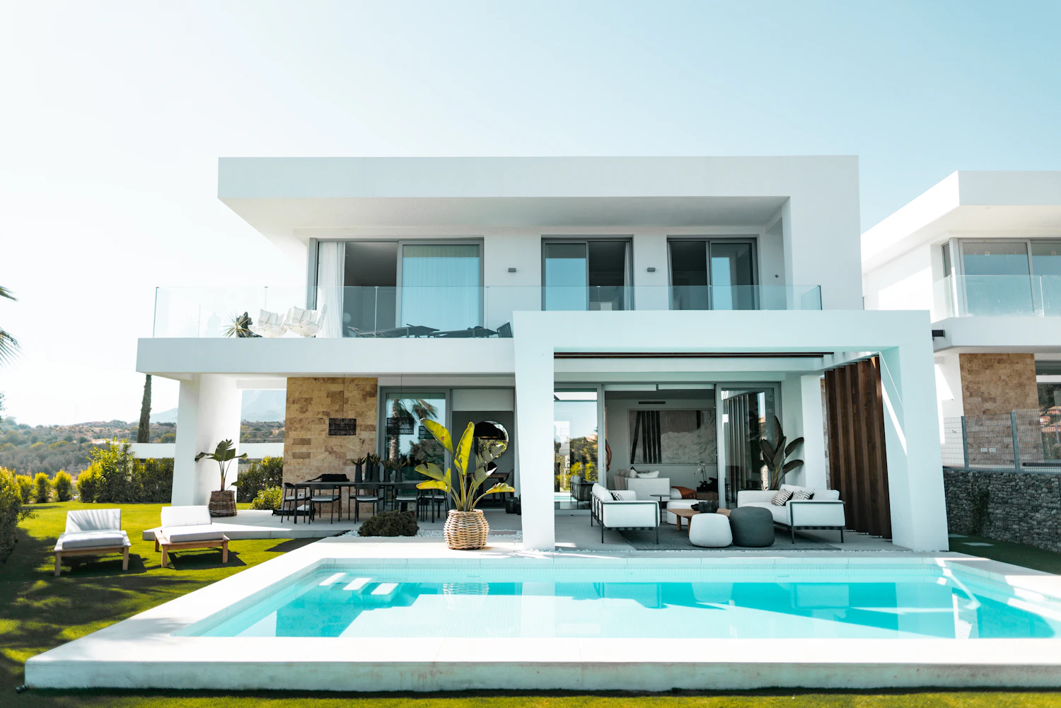 White two-storey villa with a terrace and a pool