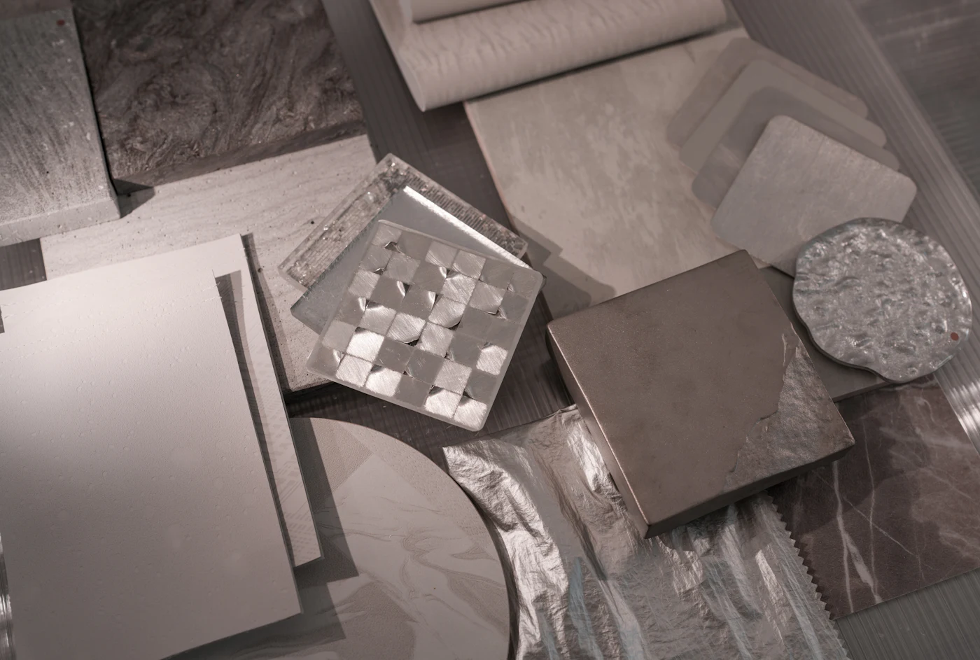 Sample pieces of stone, tile and metal finishes laid out on a table