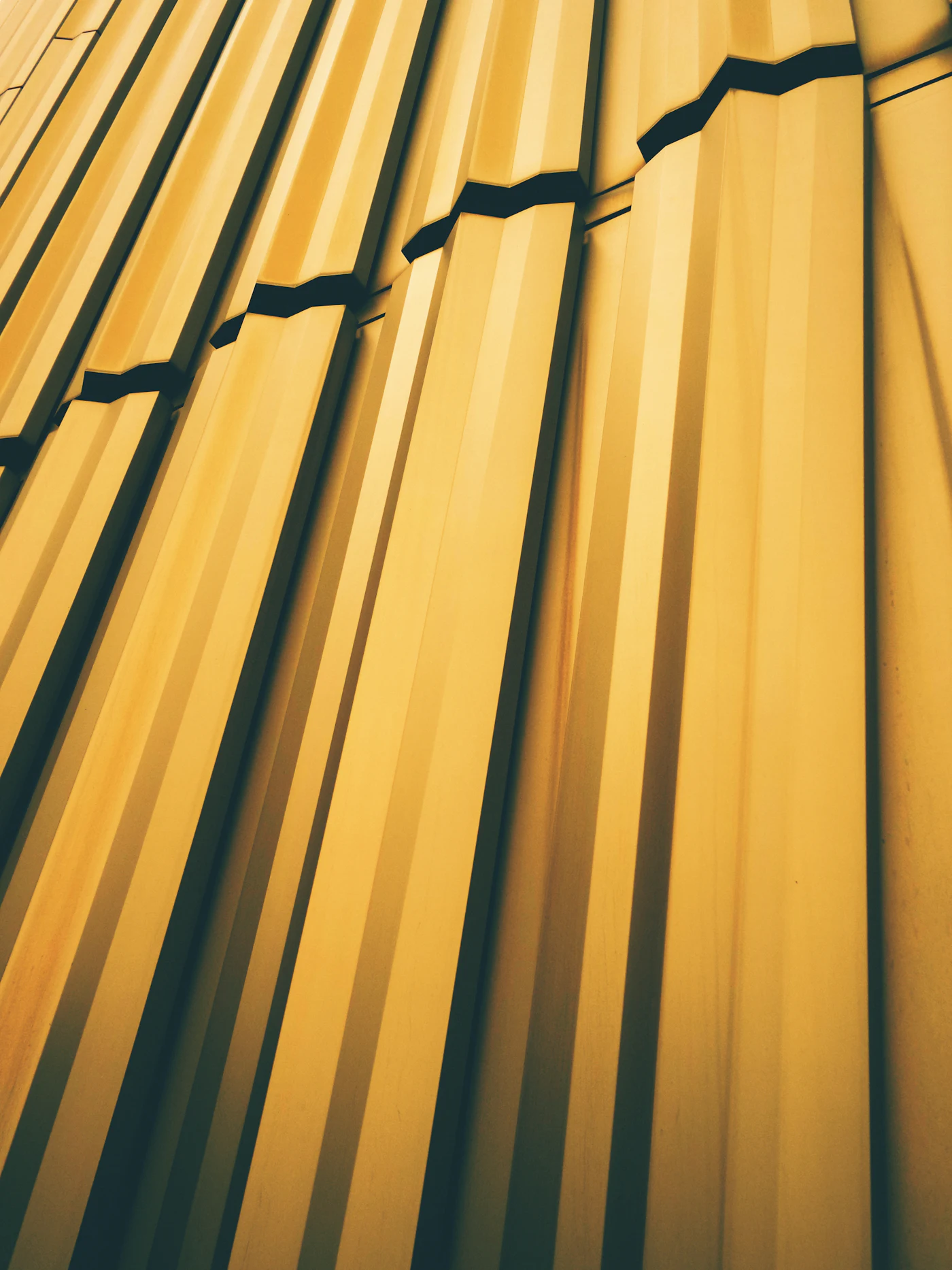 Folded yellow metal panels on the side of a building