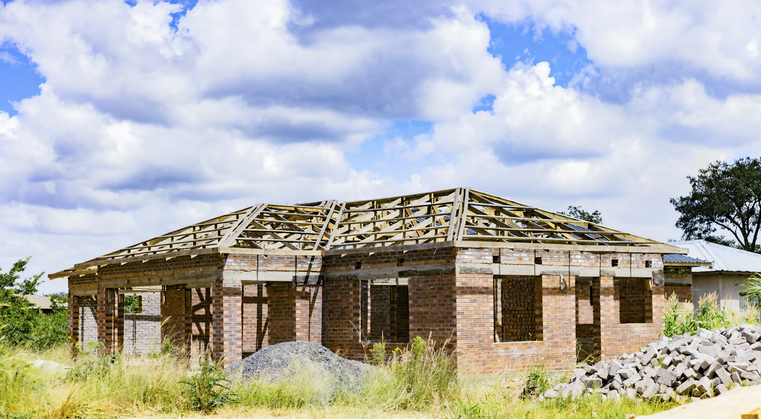 A brick house with its roof frame going up